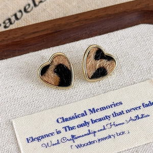 Gros plan de boucles d'oreilles cœur à motif léopard avec bordure dorée élégante