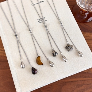 Detailed view of adjustable silver Y-necklaces with tiger eye and water drop pendants