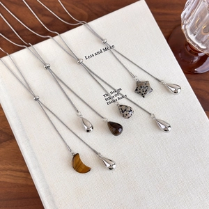 Detail of tiger eye and marble stone pendants on adjustable long sweater necklaces