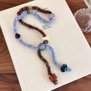 Detail of handcrafted knitted sweater chain with colorful stone beads and textile texture