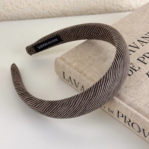 Detail of handmade brown striped headband fabric texture on a minimalist background