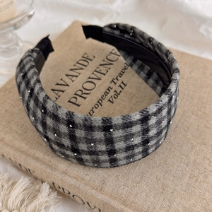 Close-up of retro plaid headband with rhinestones and anti-slip teeth on vintage book