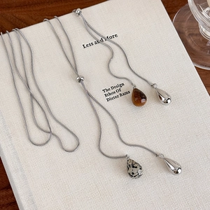 Detail of tiger eye and marble drop pendants on adjustable silver snake chain necklace