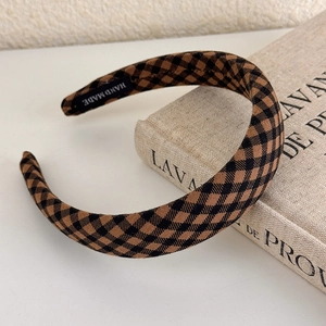 Detail of handmade brown checkerboard headband with vintage fabric texture