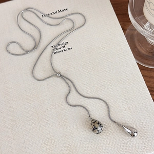 Detailed view of silver snake chain necklace with tiger eye bead and teardrop pendant