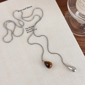 Detail view of silver Lariat necklace with tiger eye stone and polished metal drops