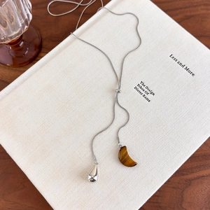 Detail of adjustable tiger eye stone pendant on silver snake chain with slider buckle