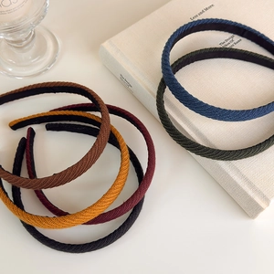 Dettaglio di cerchietti per capelli in maglia colorata in toni vintage Morandi
