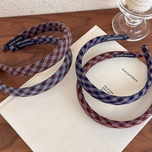 Set of four handmade plaid headbands in various vintage colors on a wooden surface