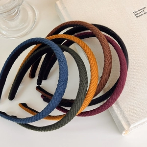 Dettaglio di cerchietti in maglia colorata con trame diagonali e finitura intrecciata