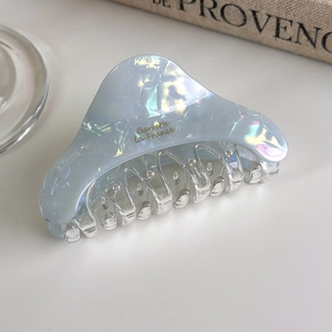 Detailed close-up of iridescent blue acetate hair claw with golden Barrette la France text