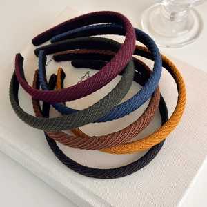 Dettaglio di cerchietti in maglia con strisce diagonali in colori della terra
