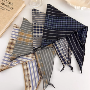 Flat lay of vintage plaid and striped triangular scarves with raw edges and cotton texture