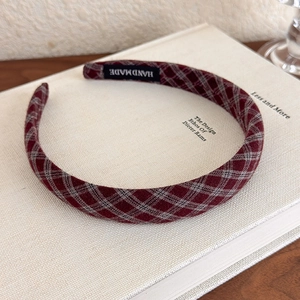 Detailed view of handmade red plaid headband featuring a classic handmade fabric label