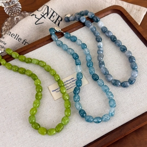 Macro view of colorful natural stone beaded necklaces on a rustic linen and wood background