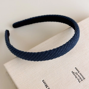 Dettaglio del cerchietto in maglia blu navy con rivestimento interno antiscivolo su libro