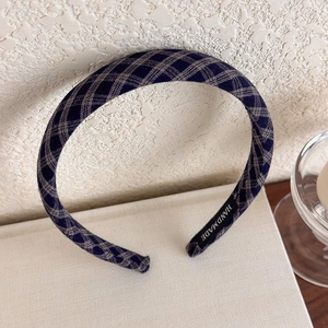 Detail of hand-made label and blue plaid fabric texture on a vintage style headband