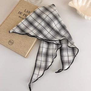 Detail of checkered retro hair scarf with black fine edges on a minimalist surface