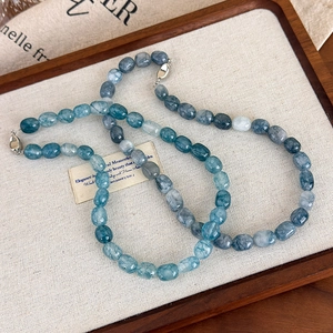 Macro shot of colorful irregular natural stone beads and silver metal clasp on a necklace