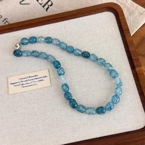 Macro detail of faceted blue natural stone beads and silver heart clasp necklace