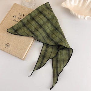 Detailed view of dark green plaid triangle scarf with refined fabric texture and stitching
