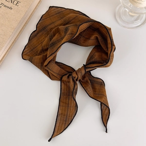 Detailed view of brown plaid silk scarf with vintage grid pattern and black stitched edges