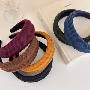 Detail of ribbed knit texture on colorful thick padded headbands stacked on a book