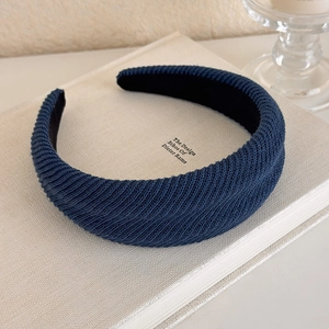 Detailed texture of a navy blue padded headband resting on a designer book