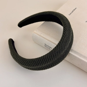Detailed close-up of dark green knitted sponge headband with textured waffle weave fabric