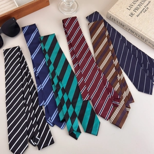 Detail shot of multi-patterned ties with stripes and polka dots on a wooden tray
