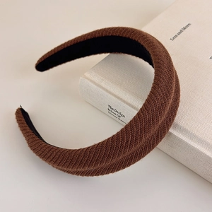 Close-up of brown knitted sponge headband with textured vertical stripes and soft fabric