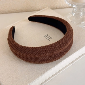 Macro shot of dark brown knit padded headband showing thick ribbed texture and craft
