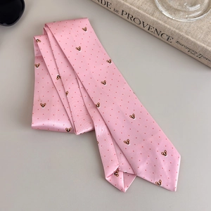 Close-up of pink satin tie with red polka dots and cute corgi print on grey background