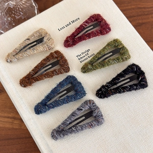 Close-up of triangle wool-wrapped snap clips in seven assorted autumn colors