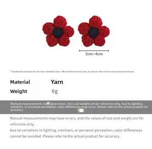 Macro view of handmade red knitted flower earrings with navy blue center and 3cm size detail