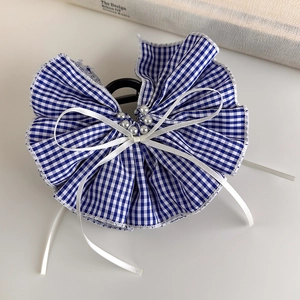 Close-up of blue plaid fabric hair claw clip with white ribbon bow and pearl details