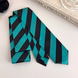 Detailed view of the green and black striped satin necktie with premium glossy finish