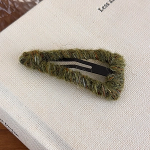 Close-up of olive green wool-wrapped triangle BB hair clip with textured yarn detail