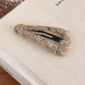 Close-up of khaki yarn-wrapped triangle snap clip with colorful speckles for autumn