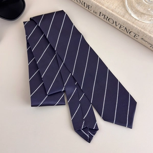 Macro detail of navy blue tie with white micro-dot stripes on smooth satin fabric