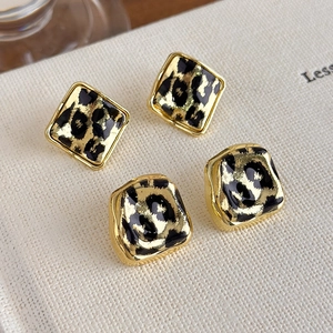 Vintage leopard print geometric earrings with gold trim on minimalist white background