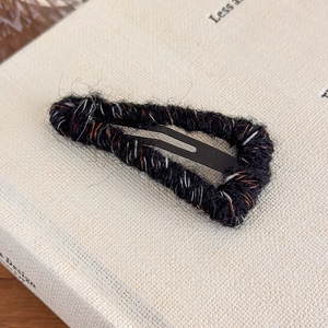 Detailed close-up of the vintage knitted wool texture on a triangular metal BB hair clip