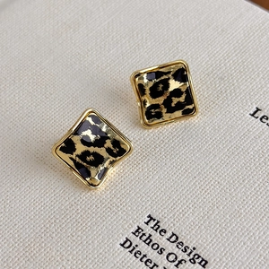 Detailed view of square leopard print earrings with a polished gold alloy edge finish
