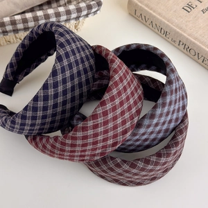 Detailed view of stacked vintage plaid padded headbands in various classic colors