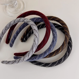 Detail of five striped knitted headbands in assorted colors with handmade textile labels