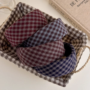 Close-up of four wide plaid padded headbands in vintage wine, navy, coffee and grey colors