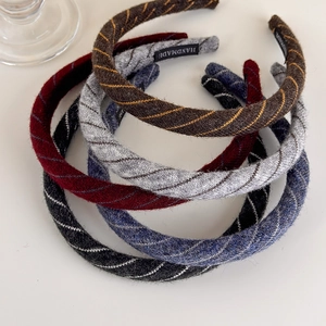 Detailed view of handmade knitted striped headbands in diverse autumn color tones
