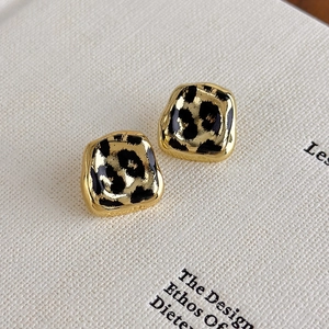 Detail of vintage leopard print square earrings with elegant gold metal borders
