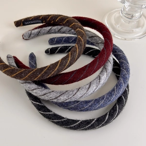 Detailed close-up of handmade knitted headbands with diagonal stripes and woven texture