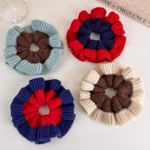 Detail of four chunky knit scrunchies showing soft wool texture and colorful patchwork design